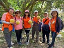 志工於柚子園拿著柚子開心合照