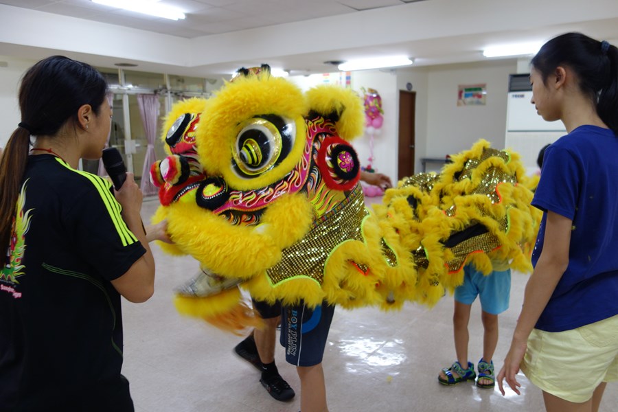 107年新住民親子生活適應輔導班第2天活動照片-學員套上黃色舞獅套裝體驗