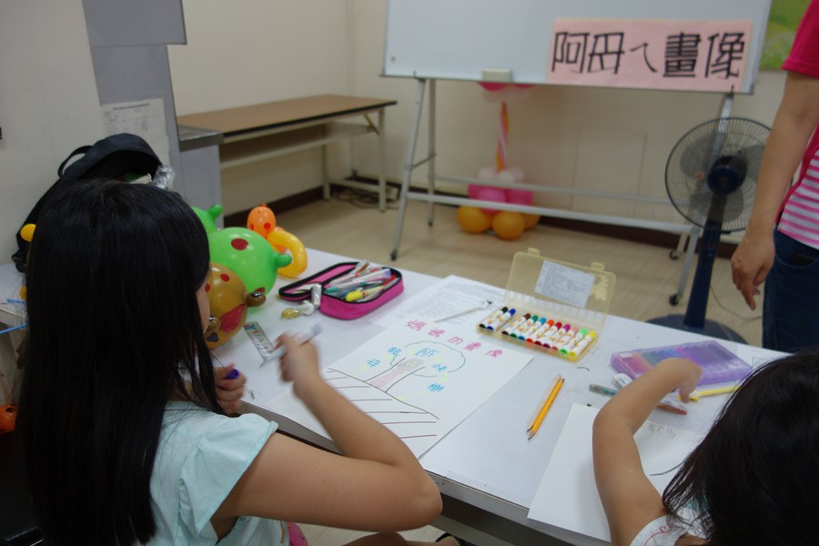 107年新住民親子生活適應輔導班第3天活動照片-小朋友專心繪製媽媽畫像